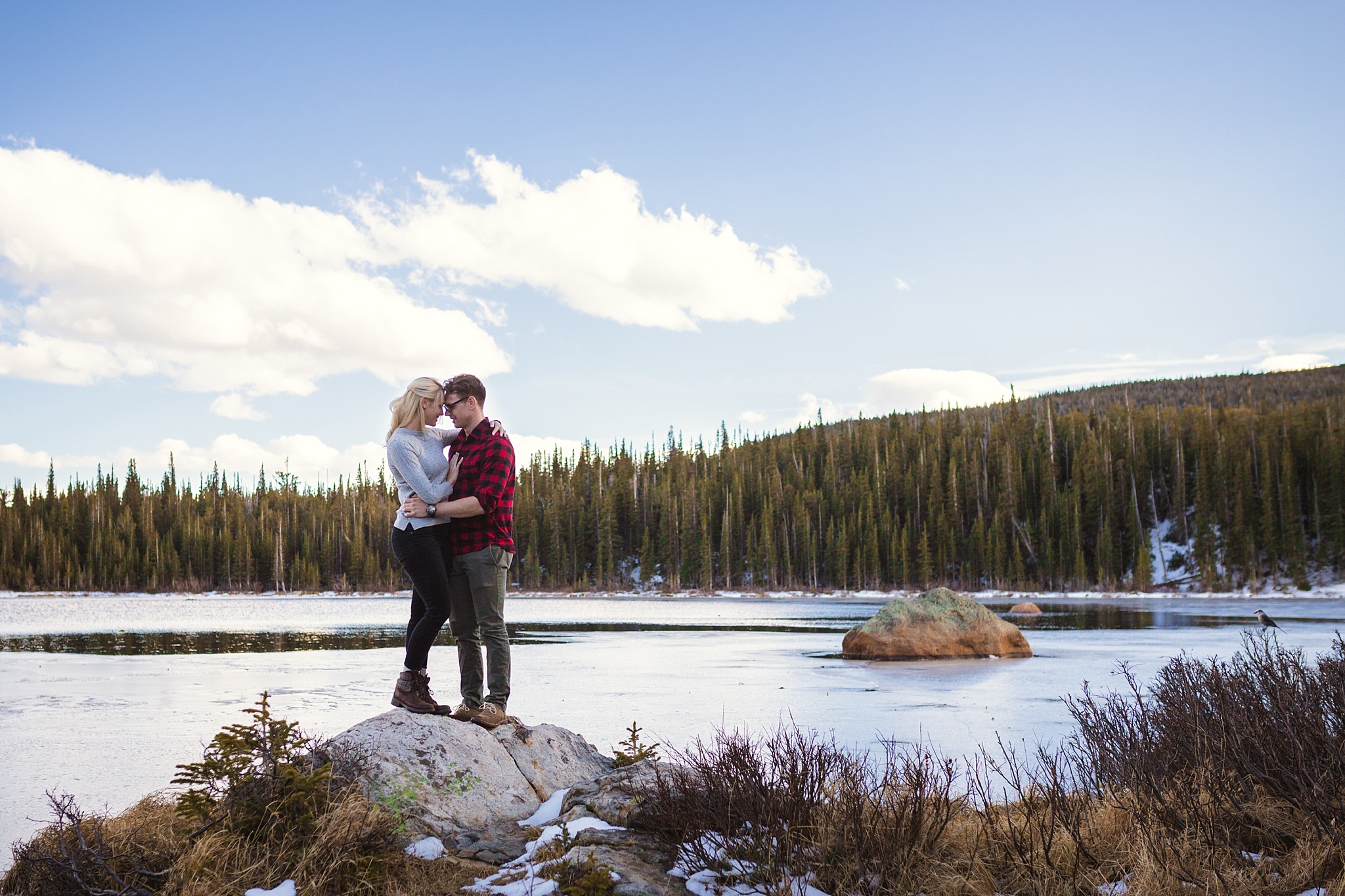 Couple embracing with a lake and mountain views during their Colorado engagement session. Amy & Jonathan’s Brainard Lake Winter Engagement Session by Colorado Engagement Photographer, Jennifer Garza. Colorado Engagement Photographer, Colorado Engagement Photography, Brainard Lake Engagement Session, Brainard Lake Engagement Photos, Mountain Engagement Session, Colorado Winter Engagement Photos, Winter Engagement Photography, Mountain Engagement Photographer, Colorado Wedding, Colorado Bride