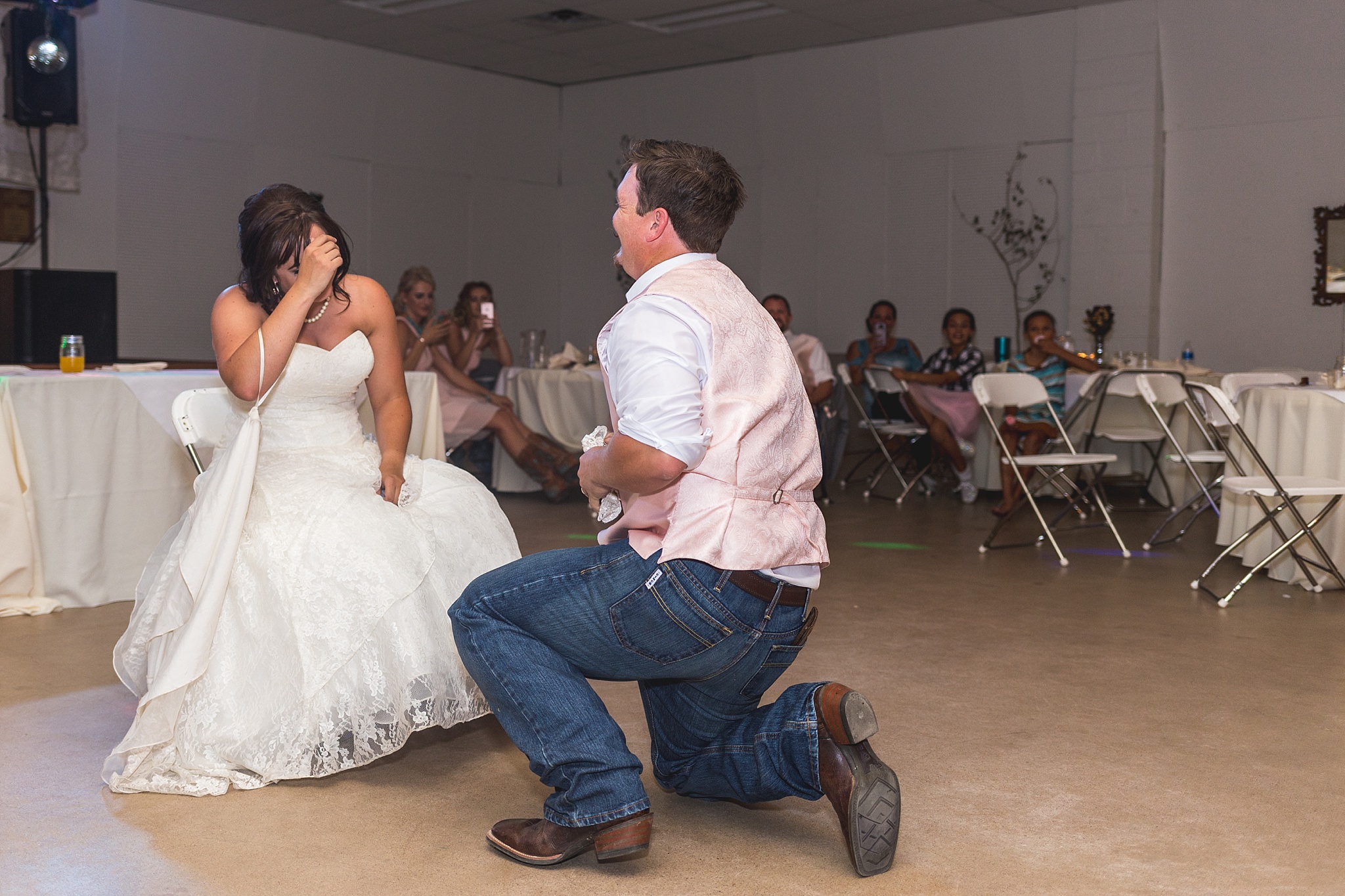 Groom getting the garter at wedding reception. Katie & Jake’s Castle Rock Wedding at the Douglas County Fairgrounds by Colorado Wedding Photographer, Jennifer Garza. Colorado Wedding Photographer, Colorado Wedding Photography, Douglas County Fairgrounds Wedding Photography, Castle Rock Wedding Photography, Castle Rock Wedding Photographer, Colorado Wedding Photography, Colorado Wedding Photographer, Colorado Wedding, Rustic Wedding, Colorado Bride, Rocky Mountain Bride