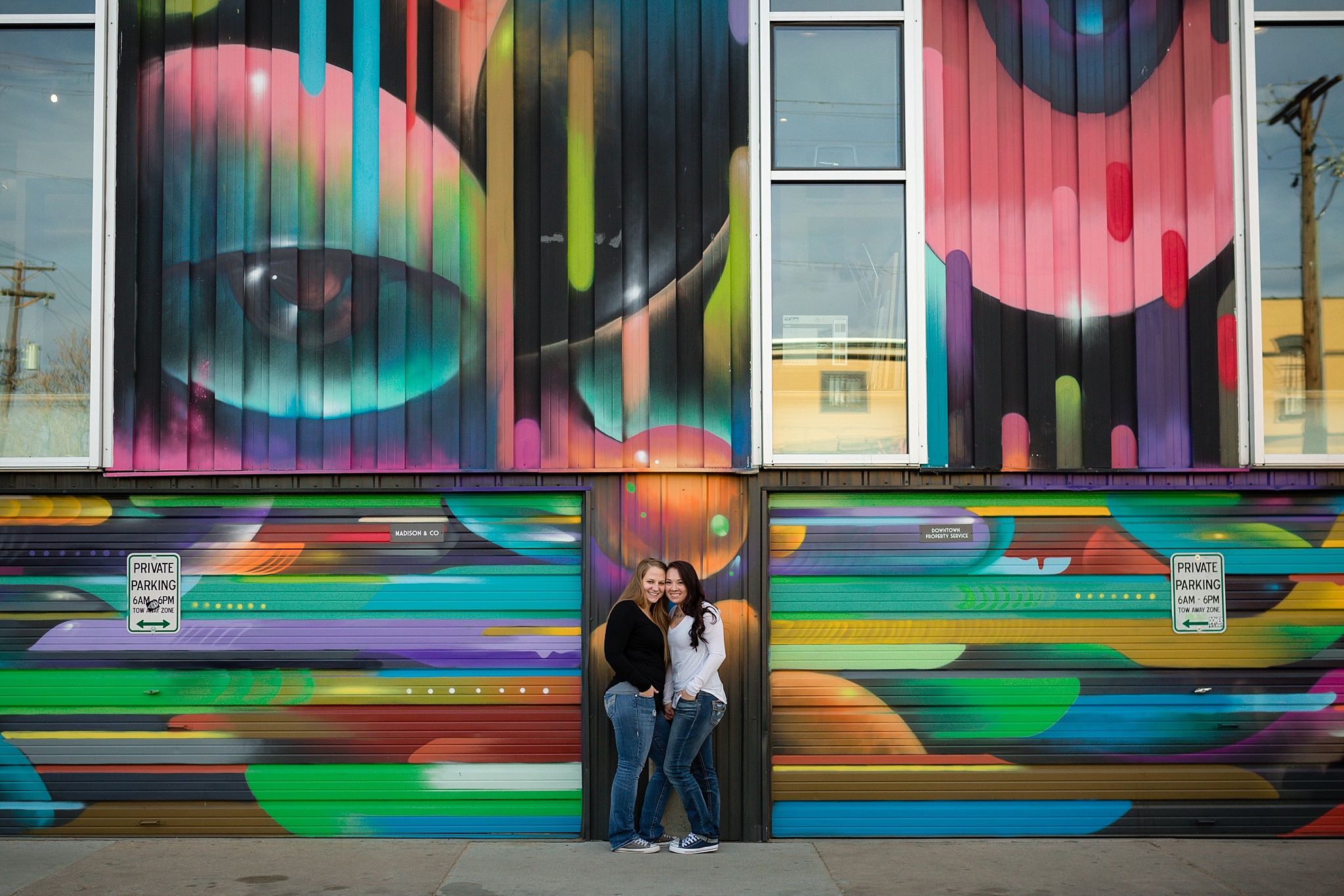 Couple standing in front of a colorful mural. Jessica & Caity’s Same-Sex Engagement Session at 10 Barrel Brewery & RiNo District by Colorado Engagement Photographer, Jennifer Garza. 10 Barrel Brewery Engagement, Brewery Engagement Photos, RiNo District Engagement Photos, RiNo District, RiNo Engagement Photography, Denver Engagement Photography, Denver Engagement, Colorado Engagement Photography, Urban Engagement Photos, Same-Sex Engagement Photography, Same-Sex Engagement Photos, Same-Sex Marriage, Love is Love, LGBTQ