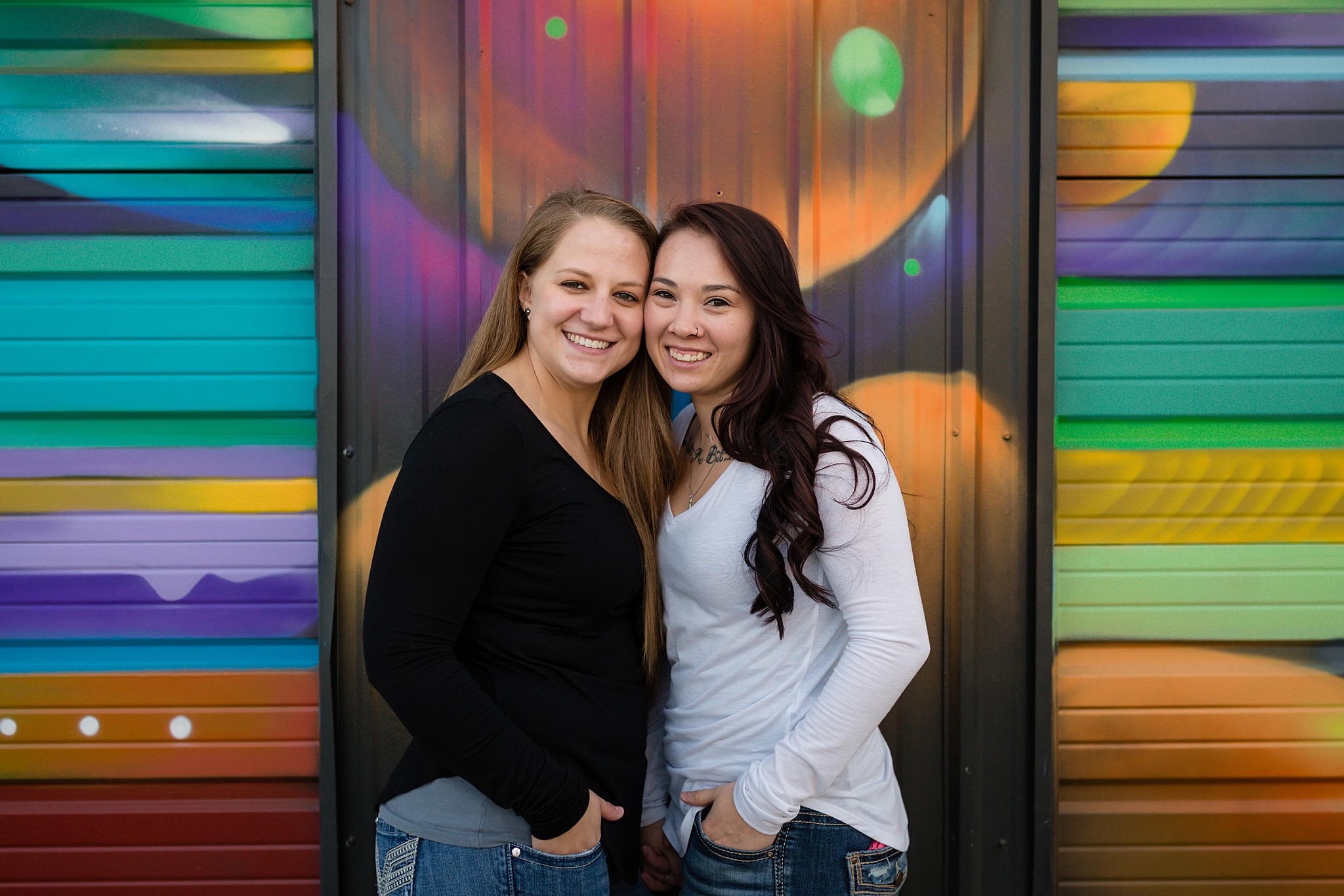 Couple standing in front of a colorful mural. Jessica & Caity’s Same-Sex Engagement Session at 10 Barrel Brewery & RiNo District by Colorado Engagement Photographer, Jennifer Garza. 10 Barrel Brewery Engagement, Brewery Engagement Photos, RiNo District Engagement Photos, RiNo District, RiNo Engagement Photography, Denver Engagement Photography, Denver Engagement, Colorado Engagement Photography, Urban Engagement Photos, Same-Sex Engagement Photography, Same-Sex Engagement Photos, Same-Sex Marriage, Love is Love, LGBTQ