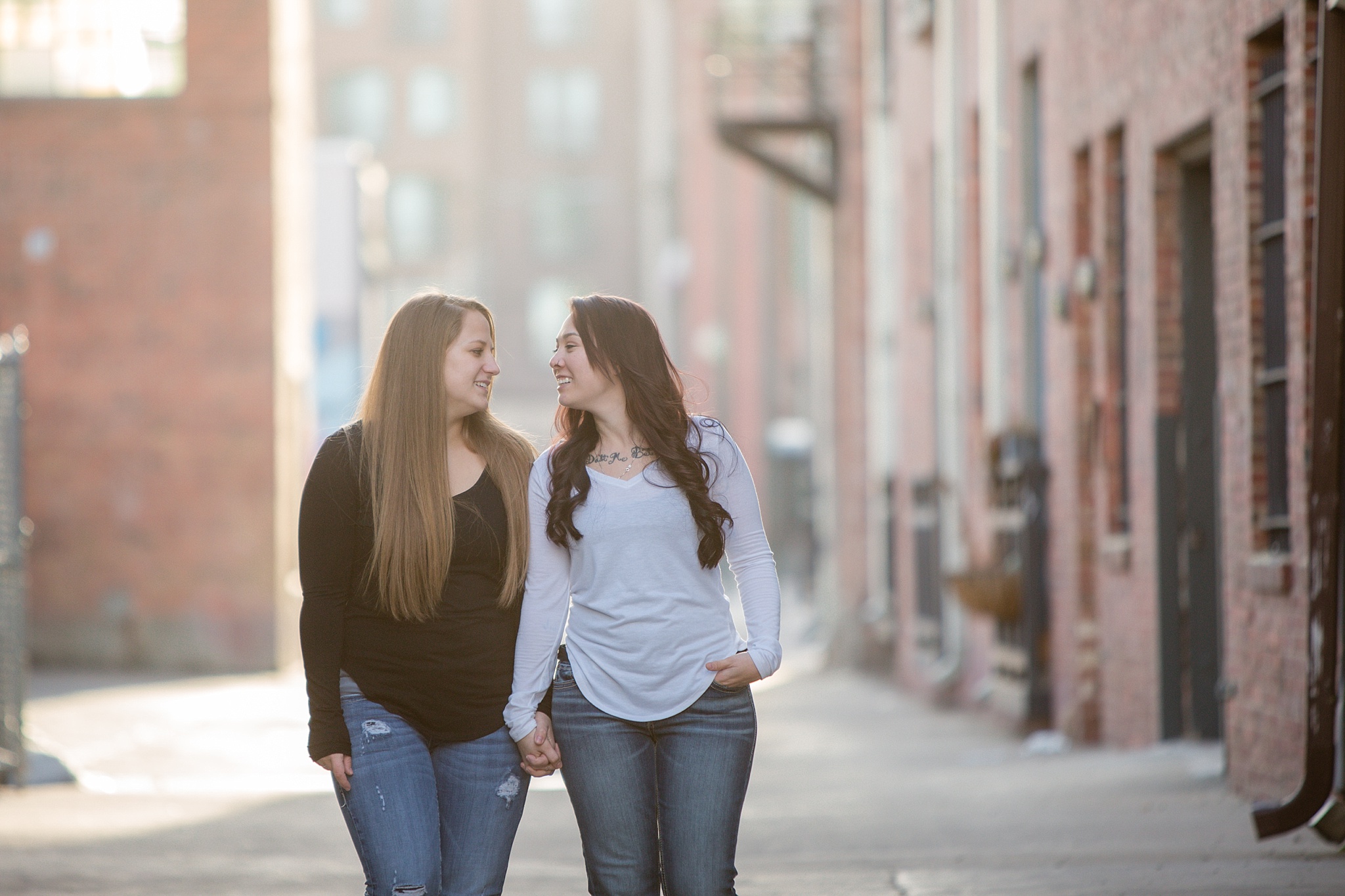 Same-sex couple walking together down an alley. Jessica & Caity’s Same-Sex Engagement Session at 10 Barrel Brewery & RiNo District by Colorado Engagement Photographer, Jennifer Garza. 10 Barrel Brewery Engagement, Brewery Engagement Photos, RiNo District Engagement Photos, RiNo District, RiNo Engagement Photography, Denver Engagement Photography, Denver Engagement, Colorado Engagement Photography, Urban Engagement Photos, Same-Sex Engagement Photography, Same-Sex Engagement Photos, Same-Sex Marriage, Love is Love, LGBTQ