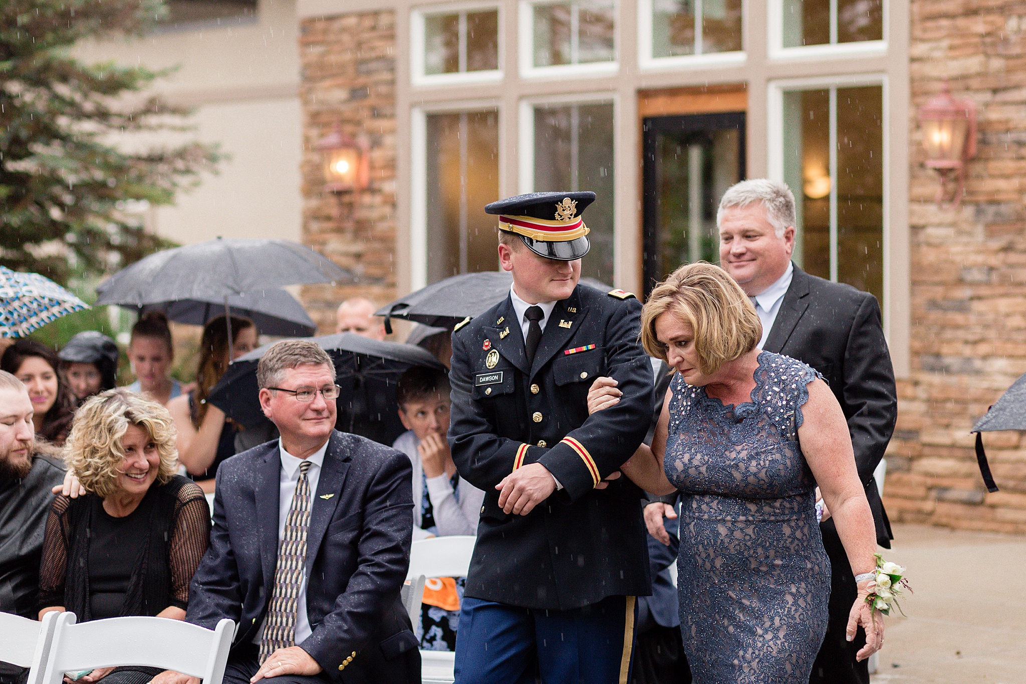 Groom walking down the aisle with his parents at a rainy summer wedding. Tania & Chris' Denver Wedding at the Wedgewood Ken Caryl by Colorado Wedding Photography, Jennifer Garza. Colorado Wedding Photographer, Colorado Wedding Photography, Denver Wedding Photographer, Denver Wedding Photography, US Marine Corp Wedding, US Marine Corp, Military Wedding, US Marines, Wedgewood Weddings, Wedgewood Weddings Ken Caryl, Colorado Wedding, Denver Wedding, Wedding Photographer, Colorado Bride