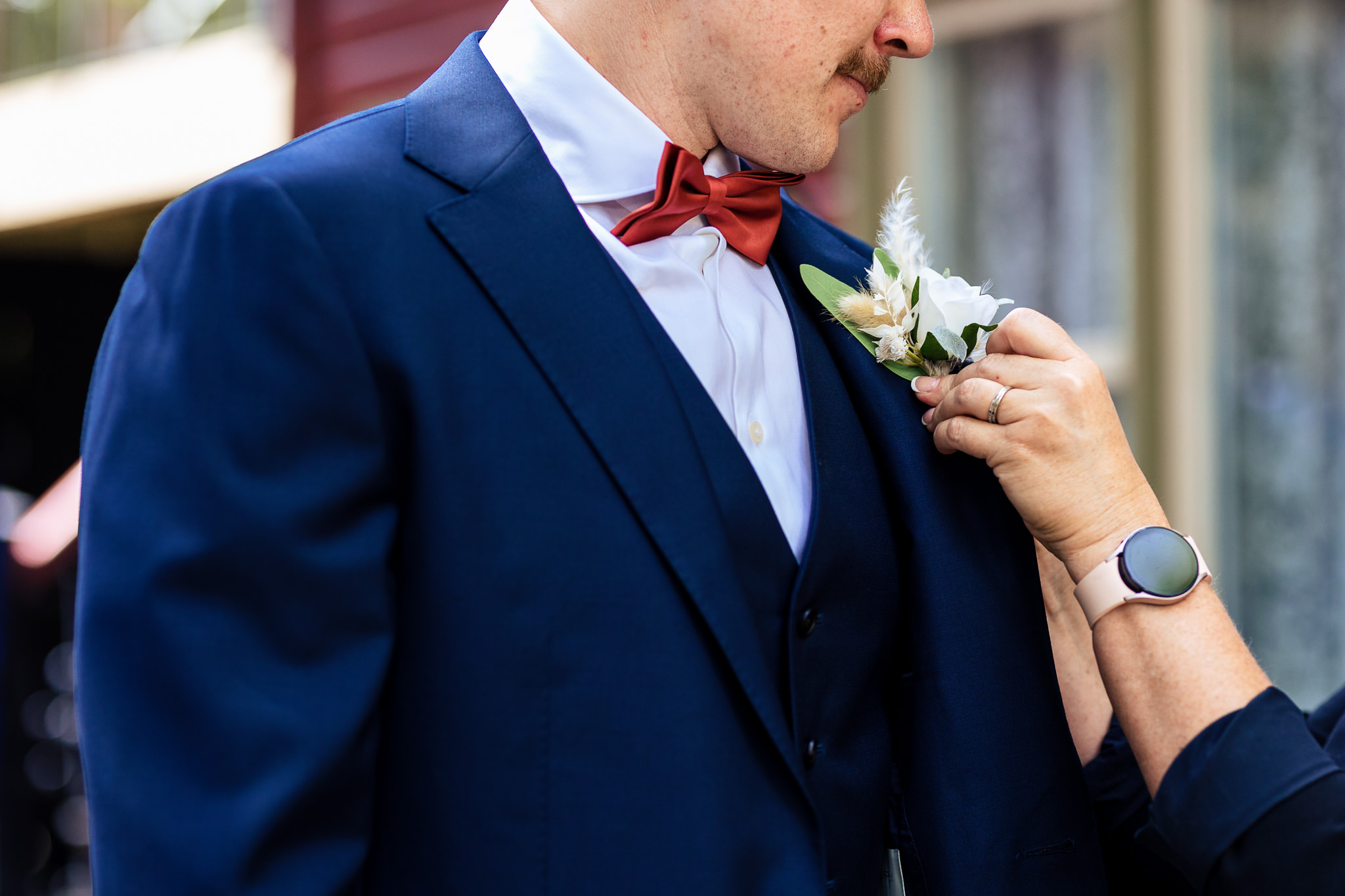 Photo of the groom having his boutonniere pinned on for Haley & Gytenis' Summer Wedding at The McCreery House by Colorado Wedding Photographer, Jennifer Garza.