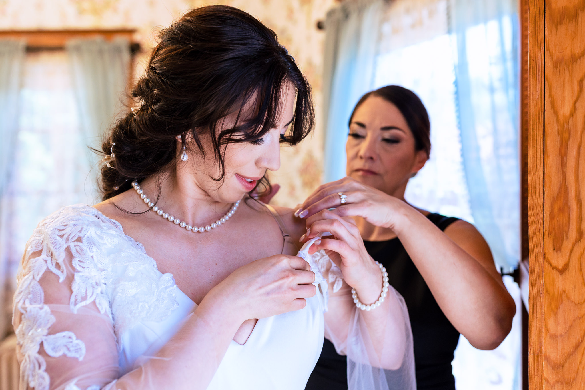 Photo of the bride putting on her dress on for Haley & Gytenis' Summer Wedding at The McCreery House by Colorado Wedding Photographer, Jennifer Garza.