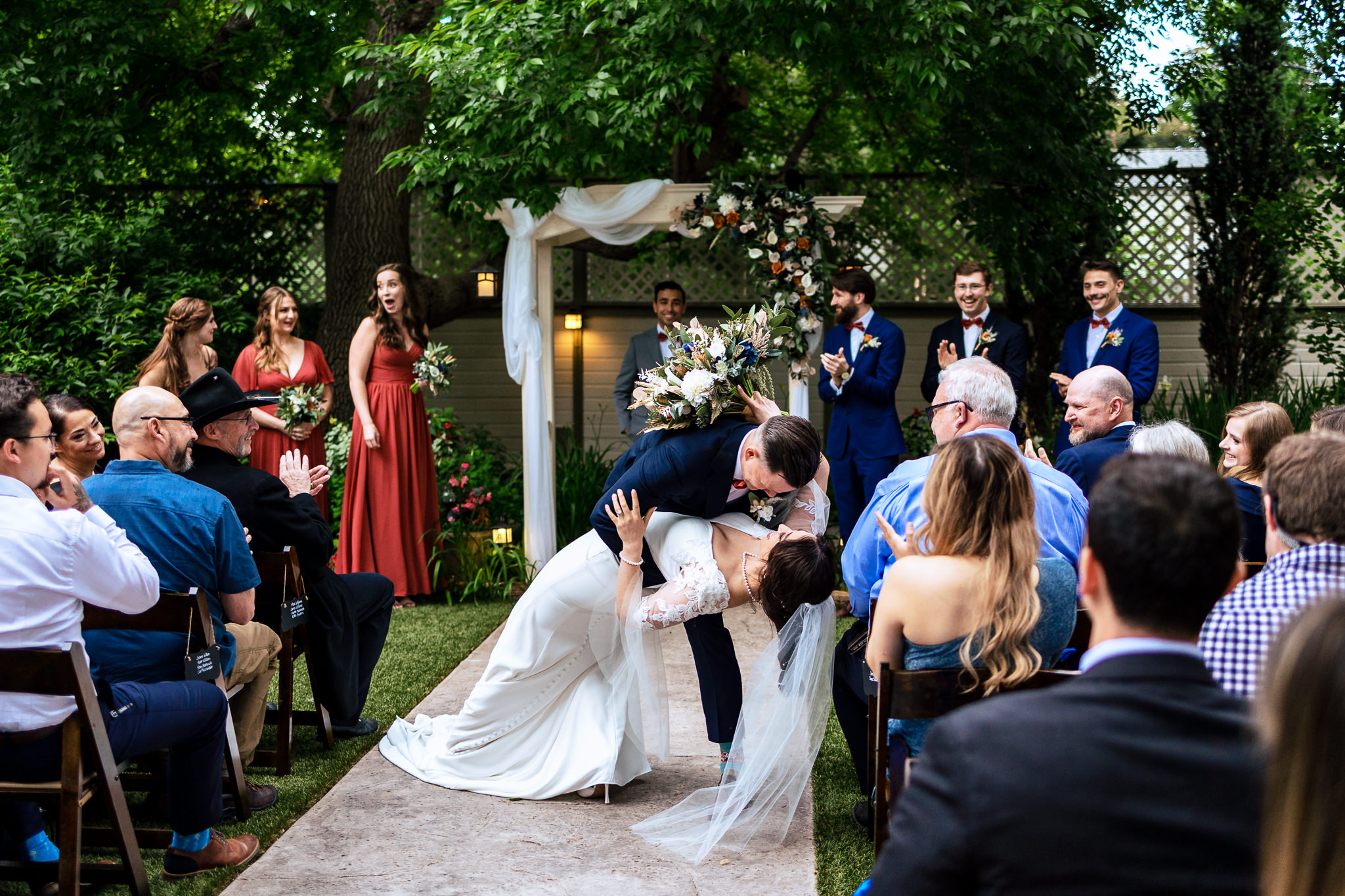 Groom dipping the Bride in the aisle to give her a kiss while walking back up the aisle after their wedding ceremony for Haley & Gytenis' Summer Wedding at The McCreery House by Colorado Wedding Photographer, Jennifer Garza.